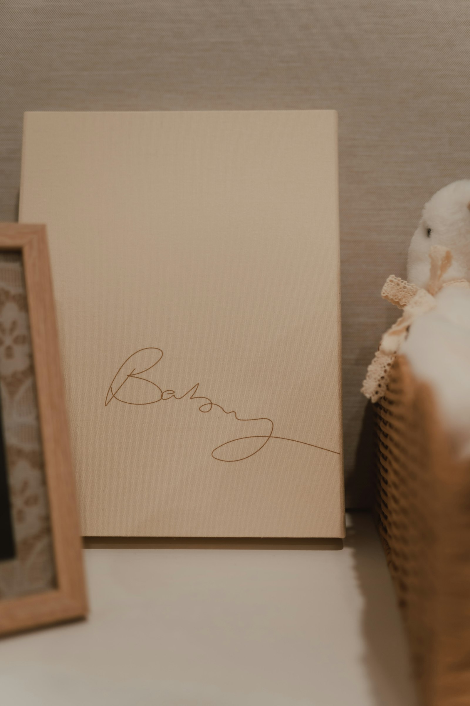 Beige keepsake card reading 'baby' beside a frame and basket