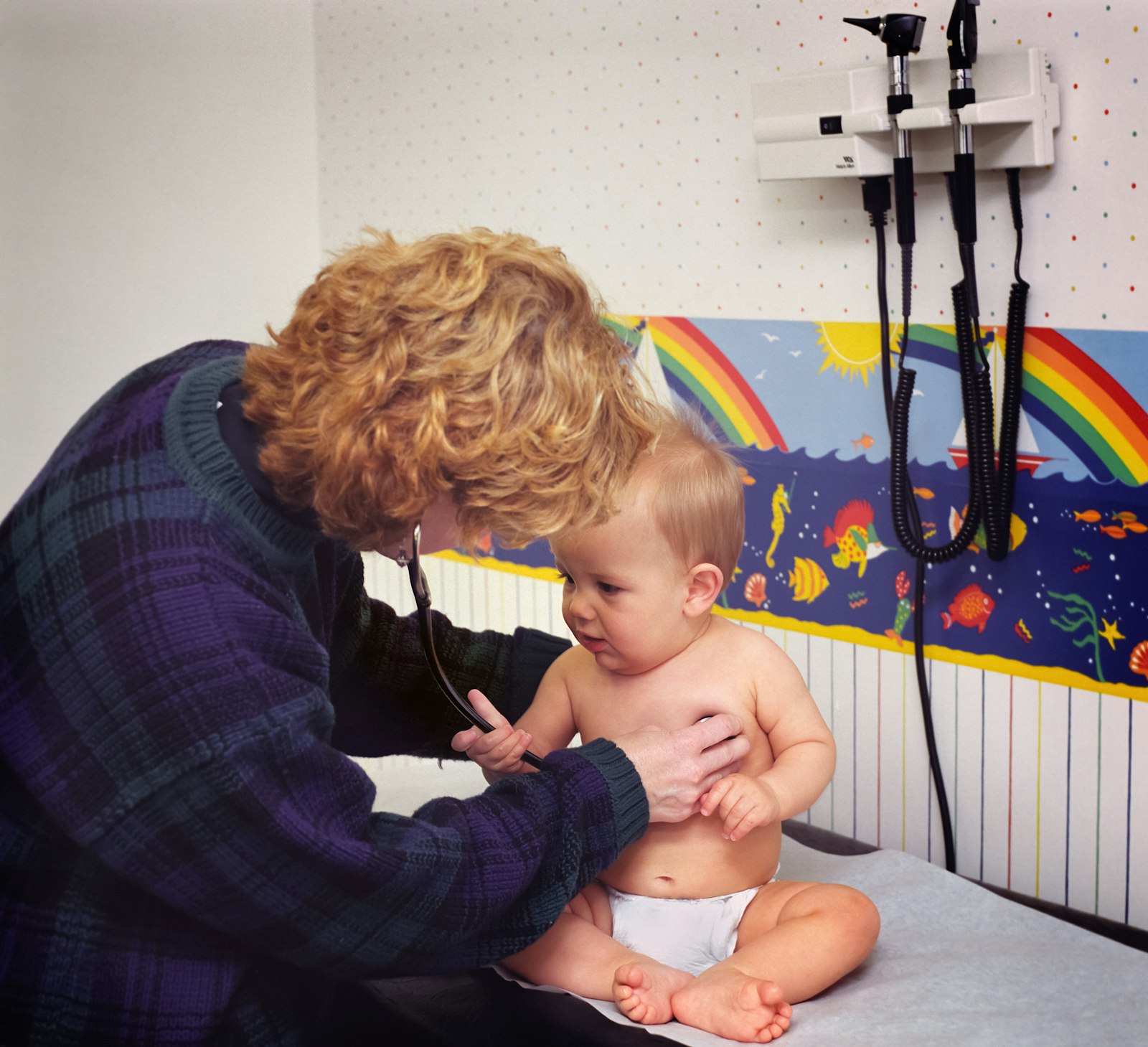 A doctor listening to a baby's chest with a stethoscope