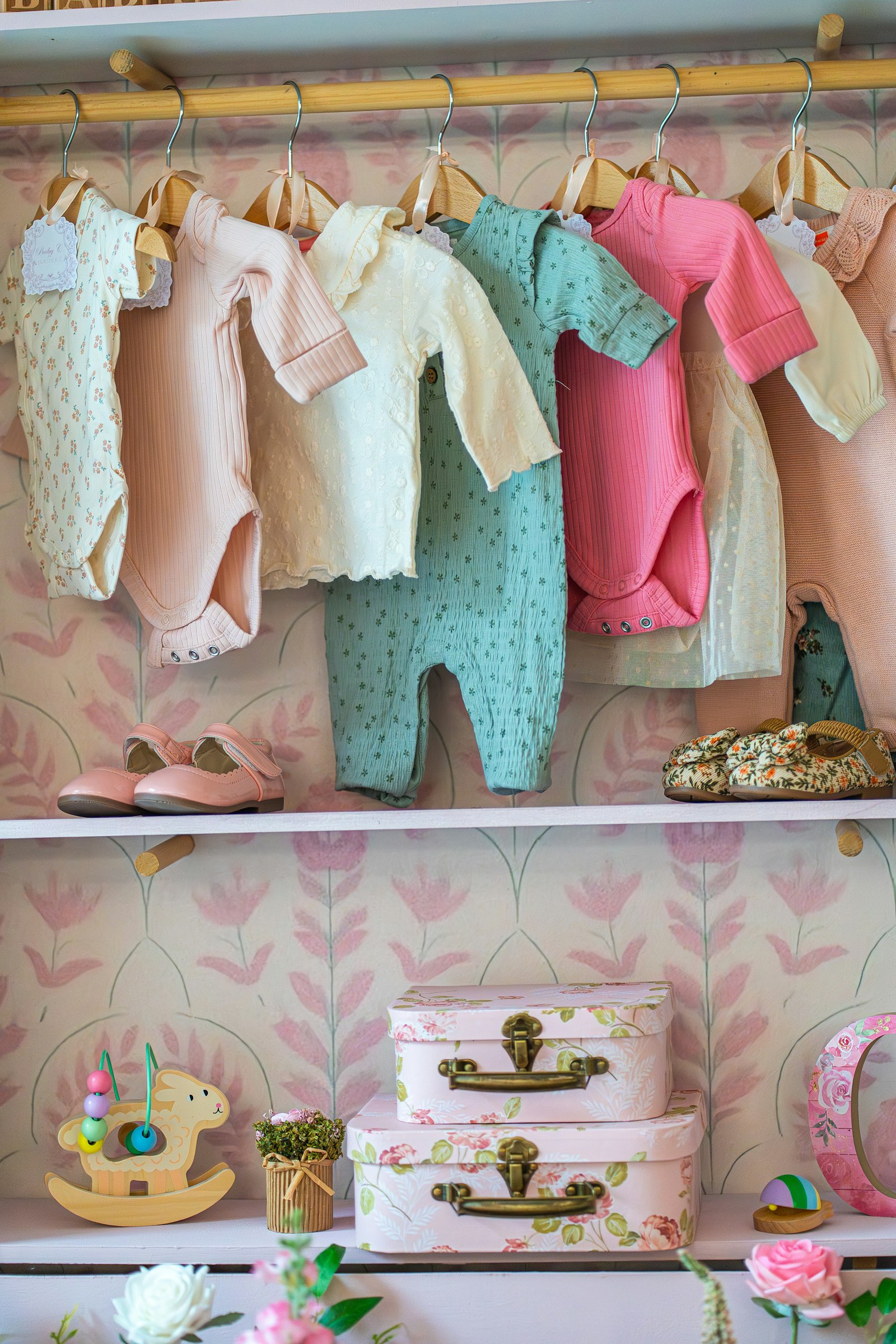 Baby clothes and shoes neatly organized on nursery shelves